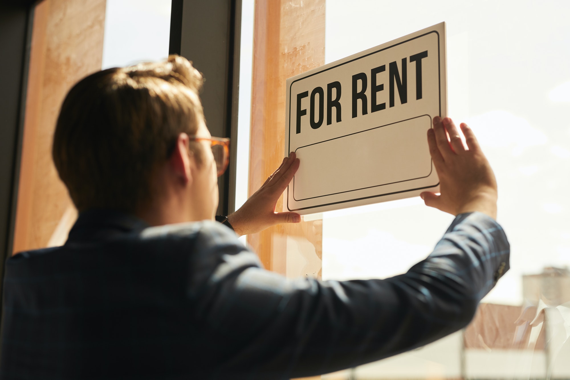 Real Estate Agent hanging For Rent Sign
